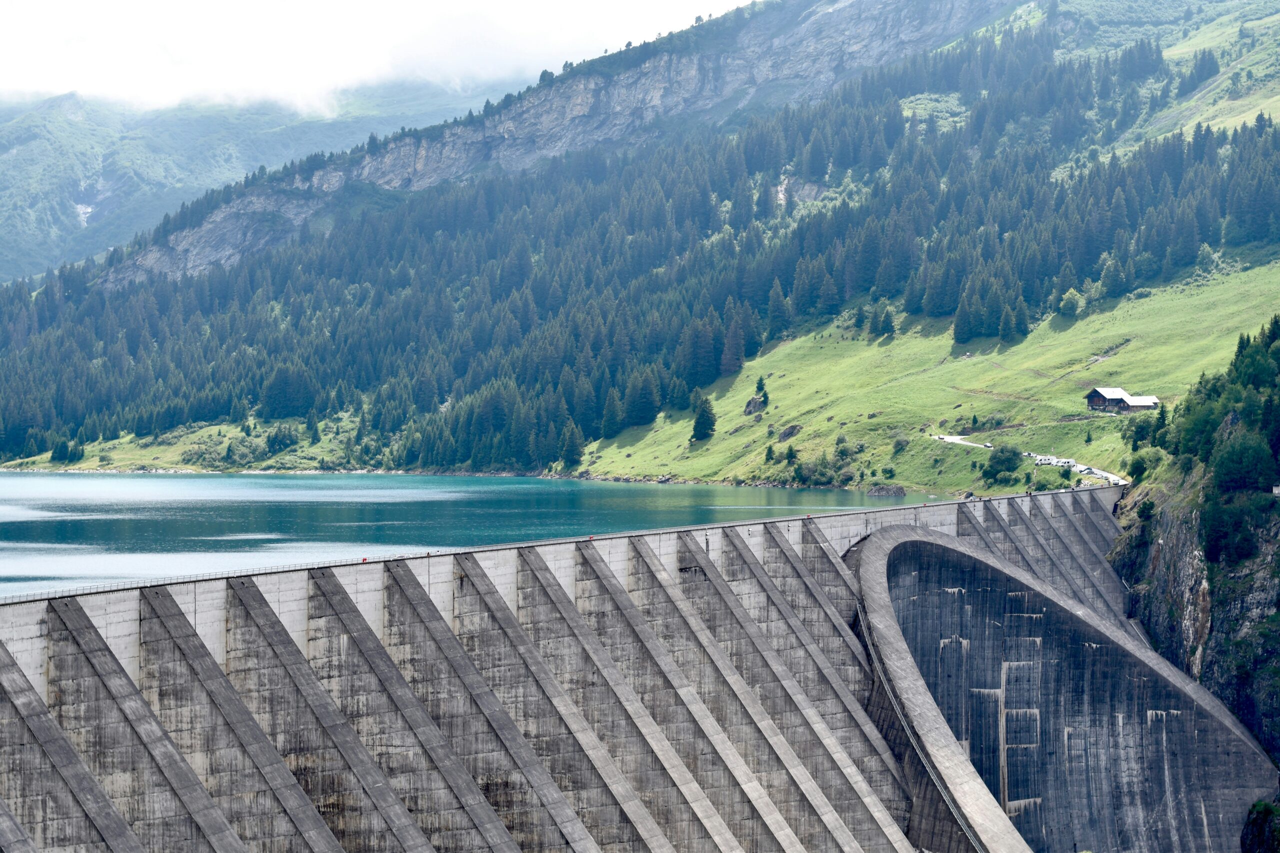 Hydroelectric dam and reservoir below green mountains