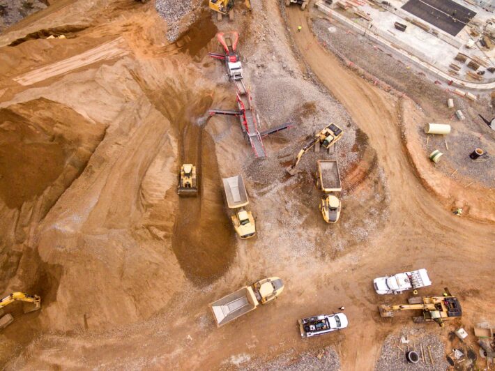 Aerial view of an open-pit mining site with excavators and haul trucks